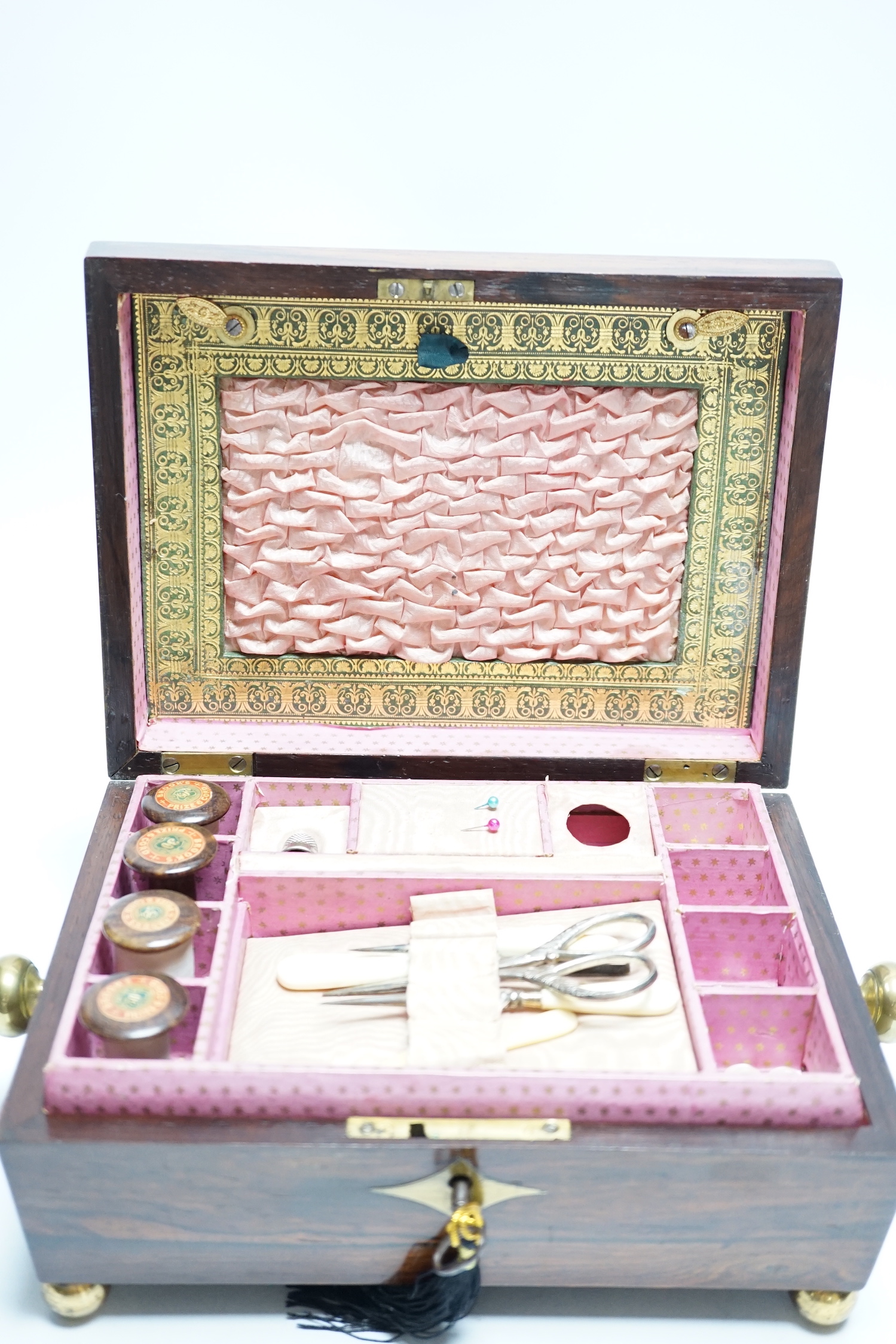 A George IV rosewood and cut brass sewing box with fitted interior, cotton reels, thread and sewing implements, 30cm wide